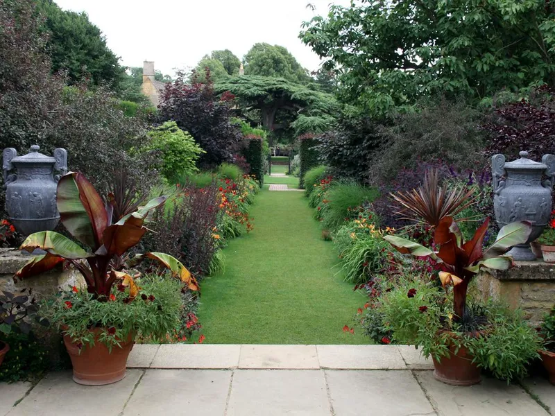 Allée de jardin aménagée bordée de massifs plantés