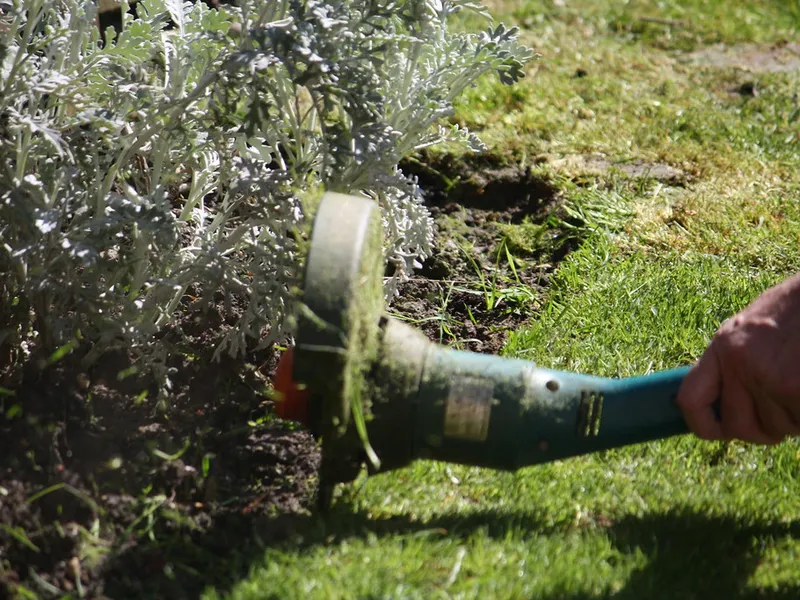 Débroussailleuse en action dans les hautes herbes
