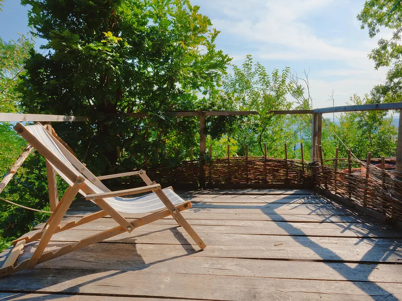 Terrasse en bois avec chaises longues donnant sur la verdure